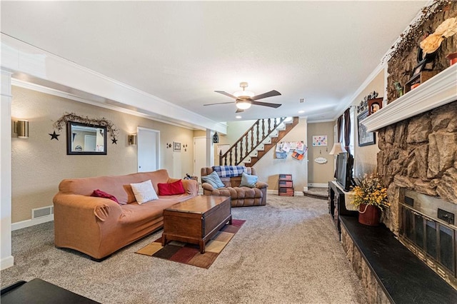 living room featuring crown molding, a stone fireplace, carpet floors, and ceiling fan