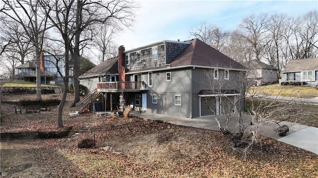 back of house with a wooden deck and a garage