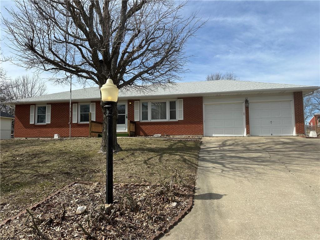 29 Winthrop Dr, Lexington, MO 64067 - ranch-style house with a garage, driveway, and brick siding