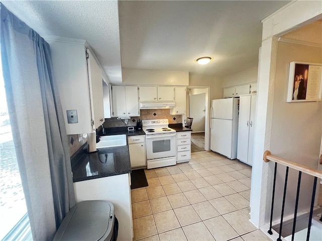 kitchen with sink, light tile patterned floors, white appliances, decorative backsplash, and white cabinets