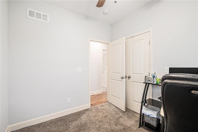 carpeted home office with ceiling fan