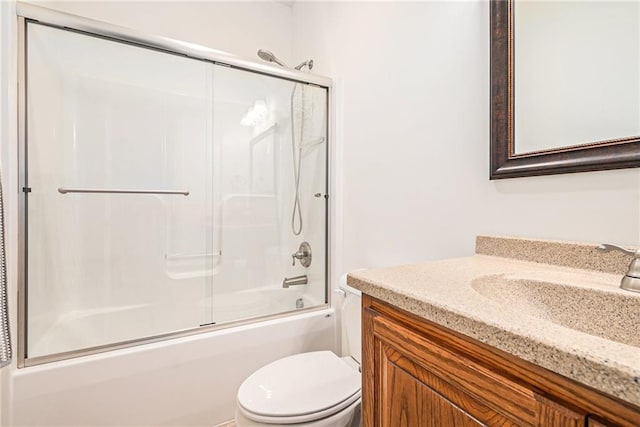 full bathroom featuring enclosed tub / shower combo, vanity, and toilet