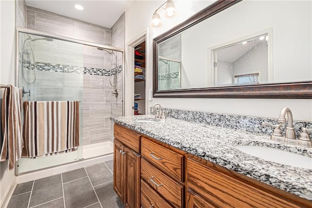 bathroom with vanity, a shower with shower door, and tile patterned flooring