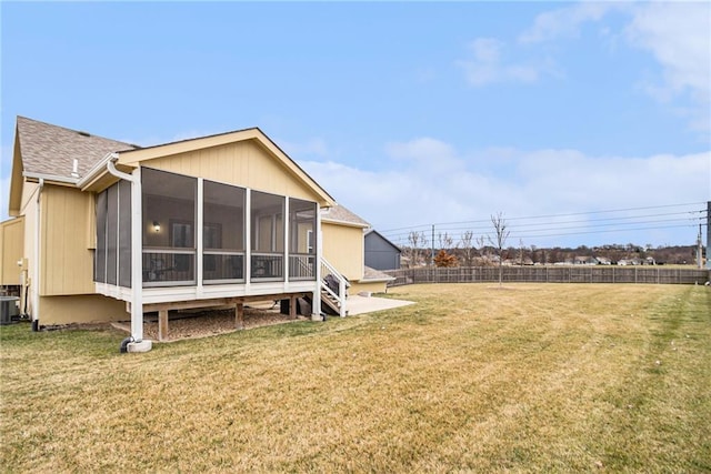 rear view of house with a yard, central AC unit, and a sunroom