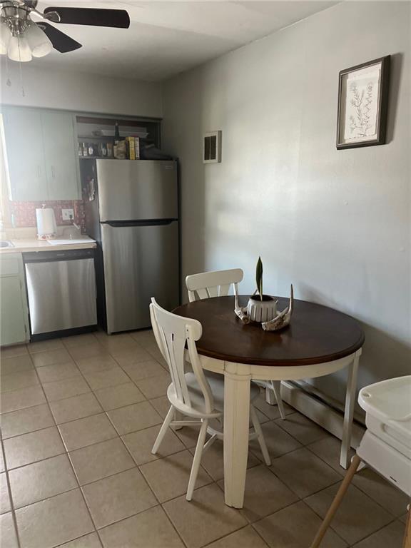 dining space with ceiling fan and light tile patterned floors