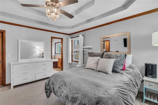 bedroom featuring ceiling fan, light colored carpet, ornamental molding, a raised ceiling, and ensuite bath