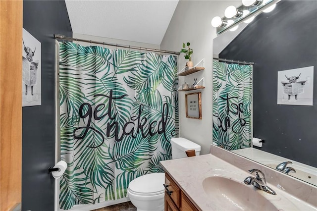 full bathroom featuring curtained shower, vanity, toilet, and a textured ceiling