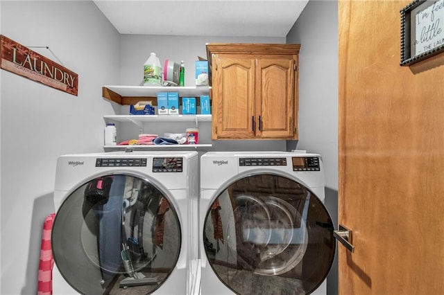 washroom with cabinet space and washer and clothes dryer