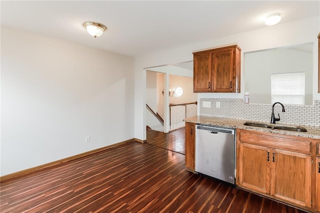 kitchen featuring sink, dark hardwood / wood-style floors, light stone countertops, decorative backsplash, and stainless steel dishwasher