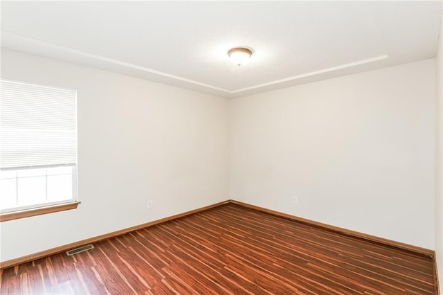 spare room featuring dark wood-type flooring