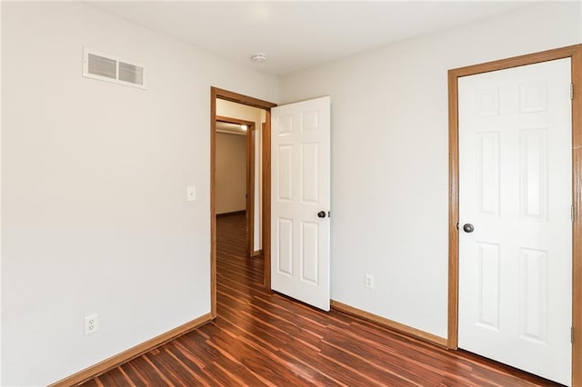 unfurnished bedroom with dark hardwood / wood-style flooring