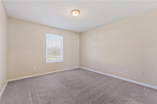 carpeted spare room featuring a textured ceiling