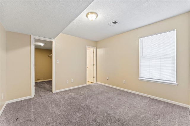 carpeted spare room featuring a textured ceiling