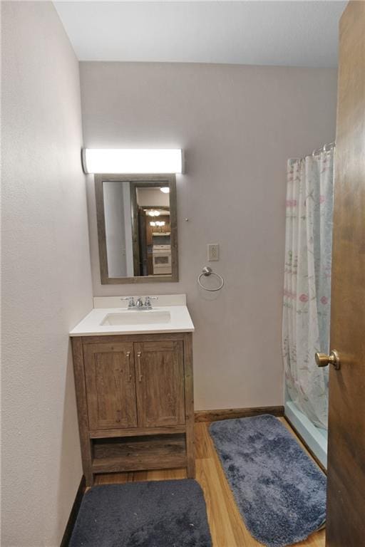 bathroom with vanity, curtained shower, and wood-type flooring