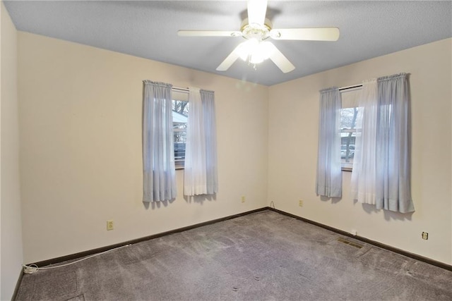 carpeted spare room with ceiling fan