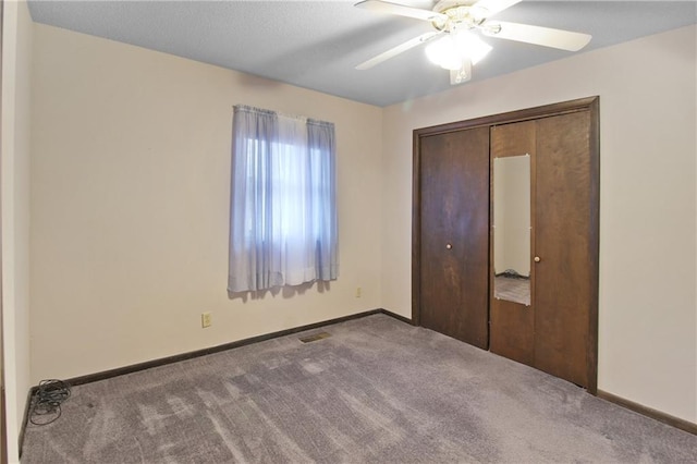 unfurnished bedroom with a closet, ceiling fan, and carpet flooring