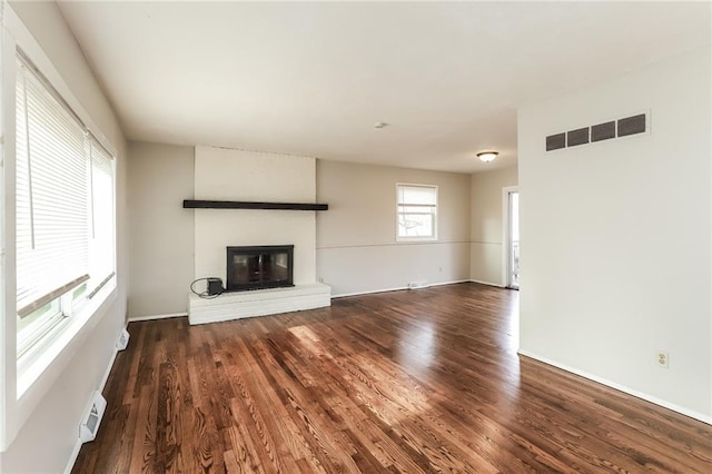 unfurnished living room with dark hardwood / wood-style floors and a fireplace