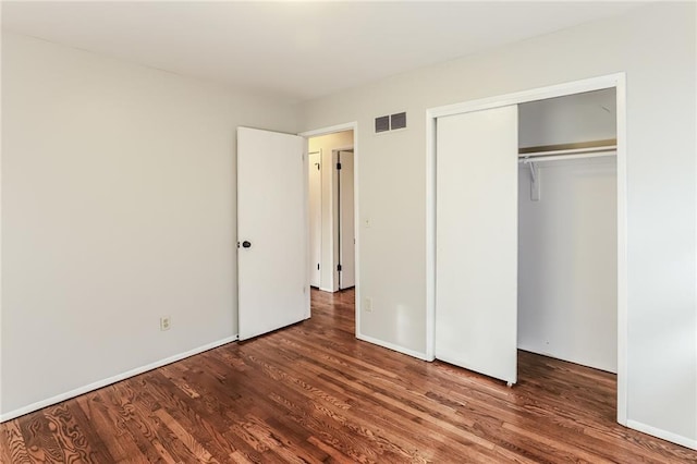 unfurnished bedroom featuring dark wood-type flooring and a closet