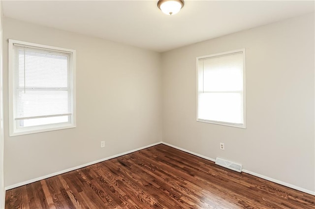 unfurnished room with dark hardwood / wood-style flooring