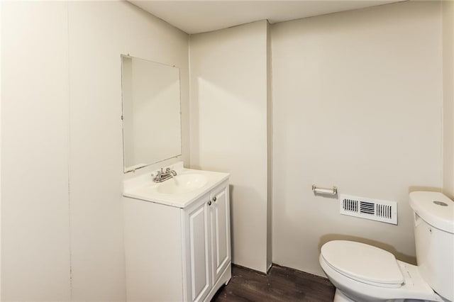 bathroom featuring vanity, toilet, and hardwood / wood-style floors