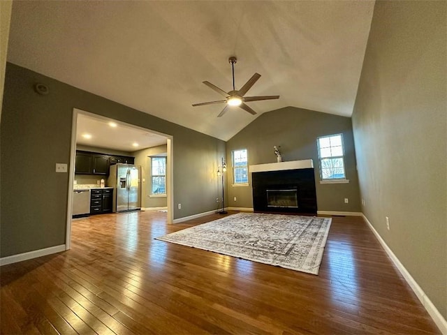 unfurnished living room featuring vaulted ceiling, dark hardwood / wood-style floors, and ceiling fan