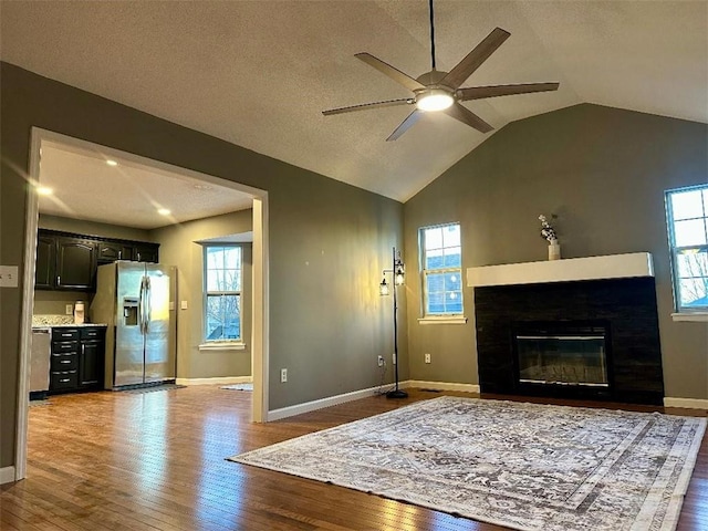 living room featuring hardwood / wood-style flooring, vaulted ceiling, and ceiling fan