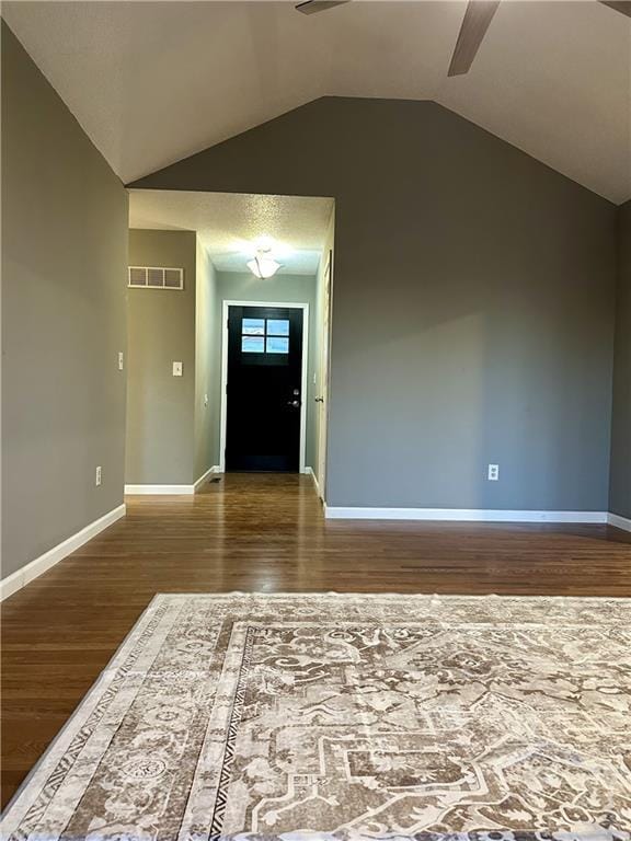 foyer entrance featuring ceiling fan, wood-type flooring, and lofted ceiling