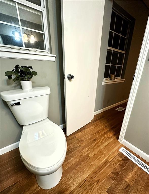 bathroom with hardwood / wood-style floors and toilet