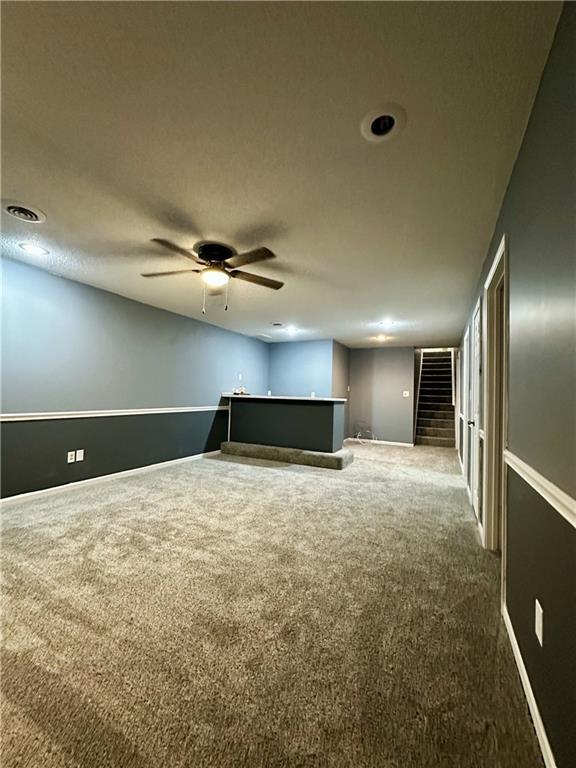 carpeted spare room with ceiling fan