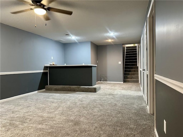 carpeted empty room featuring ceiling fan and a textured ceiling