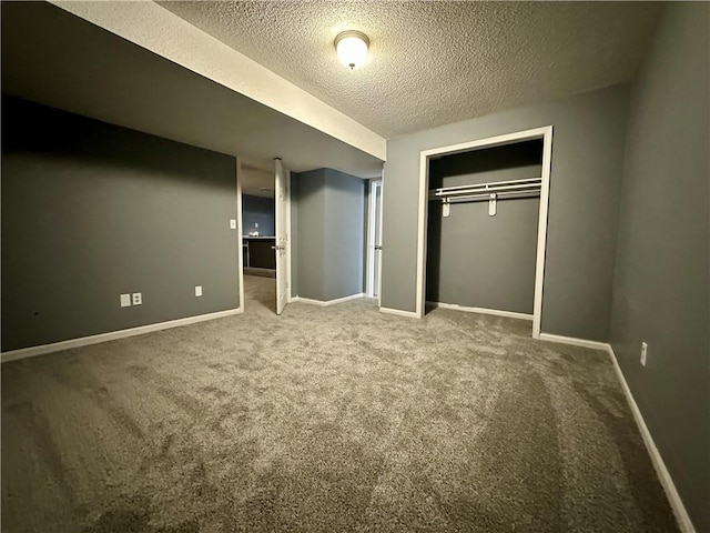 unfurnished bedroom with carpet flooring, a textured ceiling, and a closet