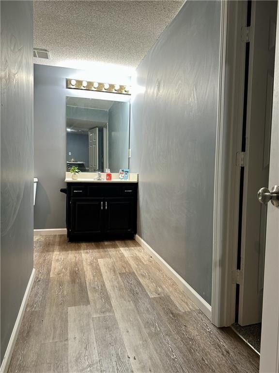 bathroom with vanity, hardwood / wood-style floors, and a textured ceiling