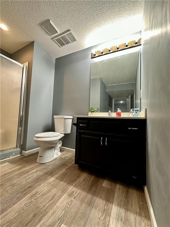 bathroom with hardwood / wood-style flooring, vanity, walk in shower, and a textured ceiling