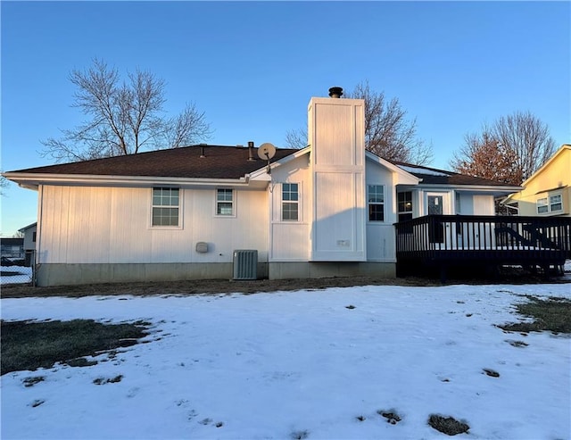 snow covered property featuring central AC and a deck