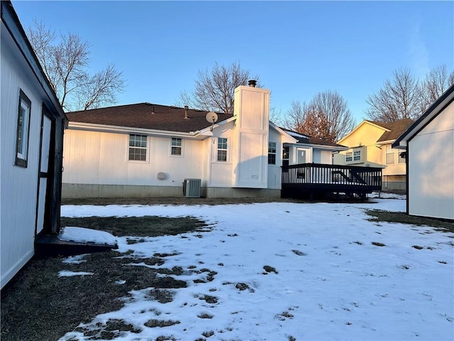 snow covered property with a wooden deck and central AC unit