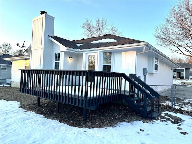 snow covered house featuring a deck