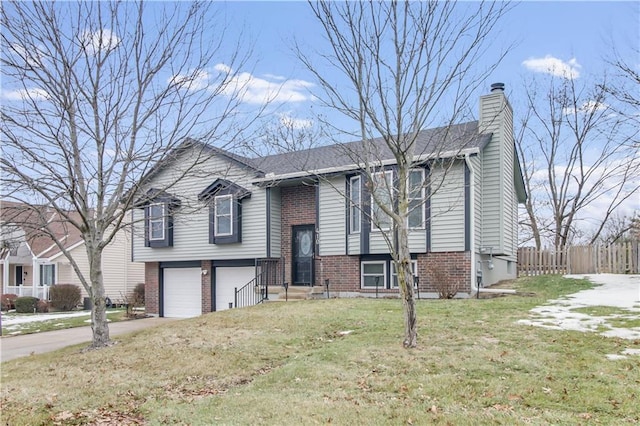 raised ranch featuring a garage and a front lawn