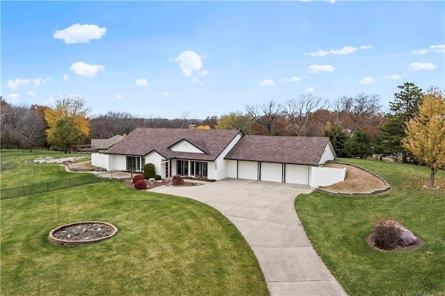 view of front of property with an attached garage, fence, a front lawn, and concrete driveway