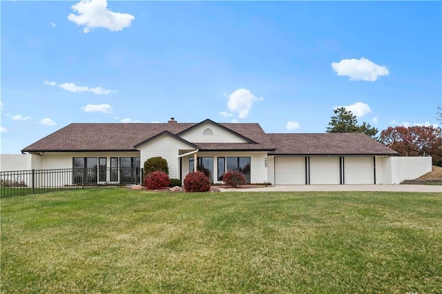 view of front facade featuring a garage, driveway, fence, and a front yard