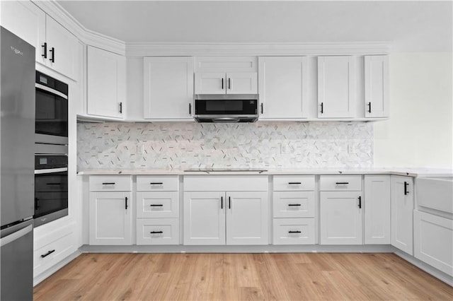 kitchen featuring light wood finished floors, stainless steel appliances, and light countertops