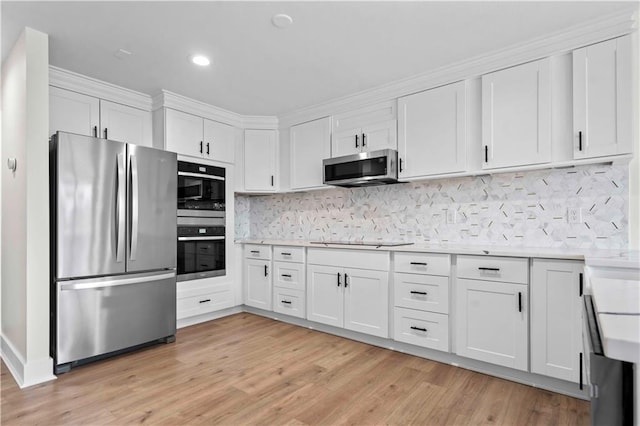 kitchen featuring stainless steel appliances, light countertops, and white cabinetry