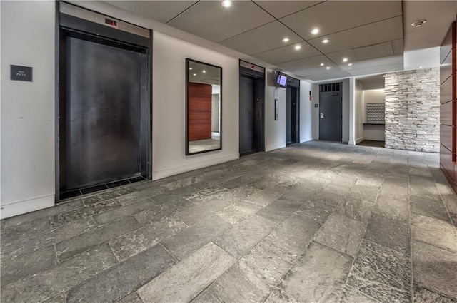 spare room featuring elevator and a drop ceiling