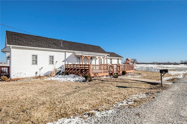 snow covered property with a lawn and a deck