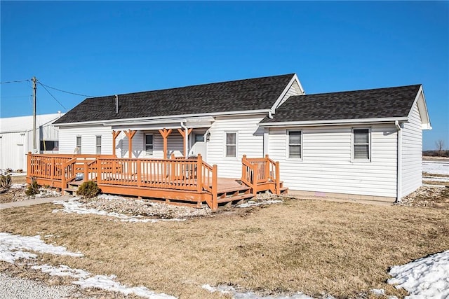 snow covered property featuring a deck and a lawn