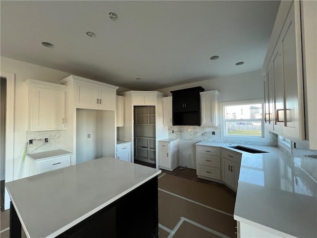 kitchen with white cabinetry, a center island, and decorative backsplash