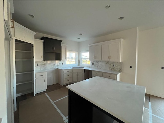 kitchen featuring white cabinetry, dark hardwood / wood-style floors, a kitchen island, and tasteful backsplash