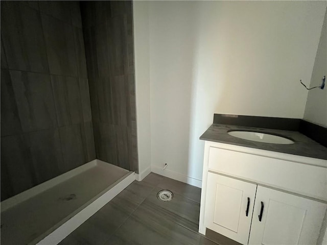 bathroom with tile patterned flooring, vanity, and walk in shower