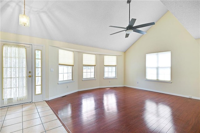 foyer entrance featuring ceiling fan, high vaulted ceiling, hardwood / wood-style floors, and a textured ceiling