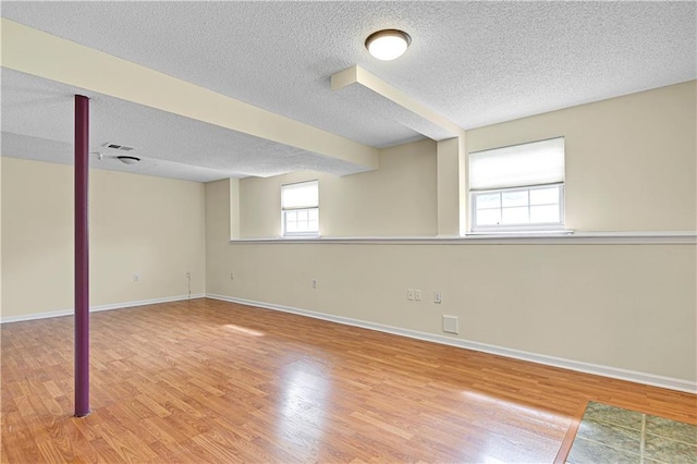 basement with wood-type flooring and a textured ceiling