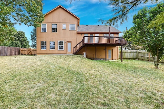 rear view of house with a wooden deck and a yard